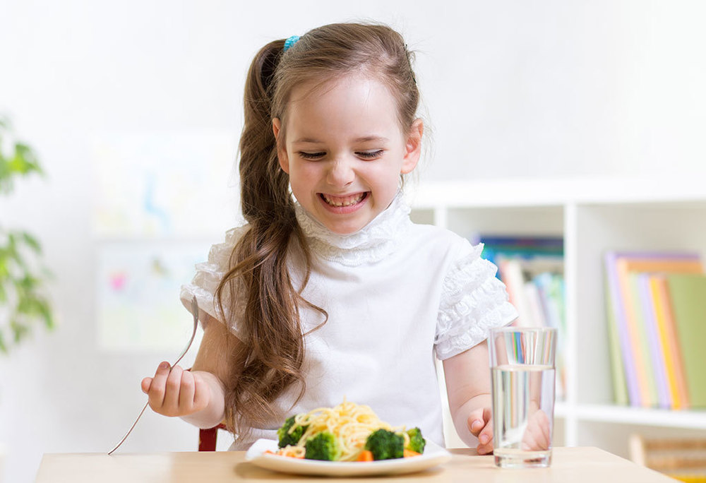 Child happy to be eating broccoli
