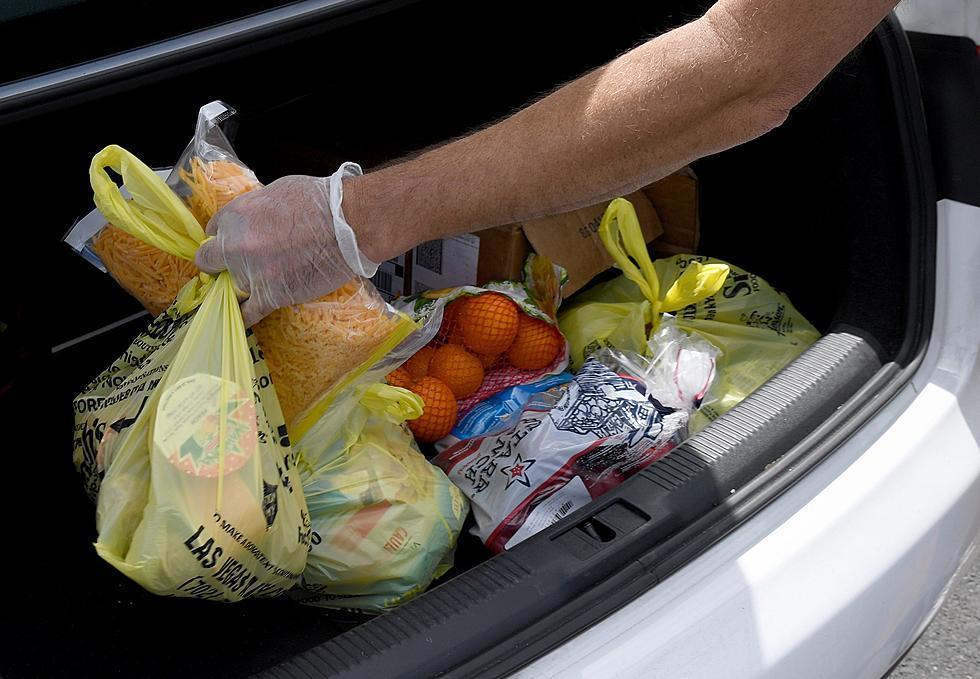 Person placing food pantry items into trunk