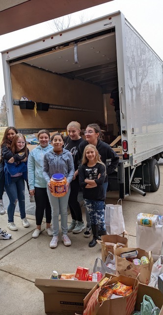 Emily G. Johns students helping load the truck with the food pantry donations.