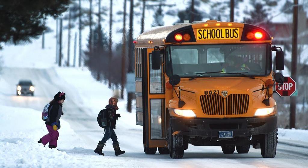 Student getting on bus on snowy day