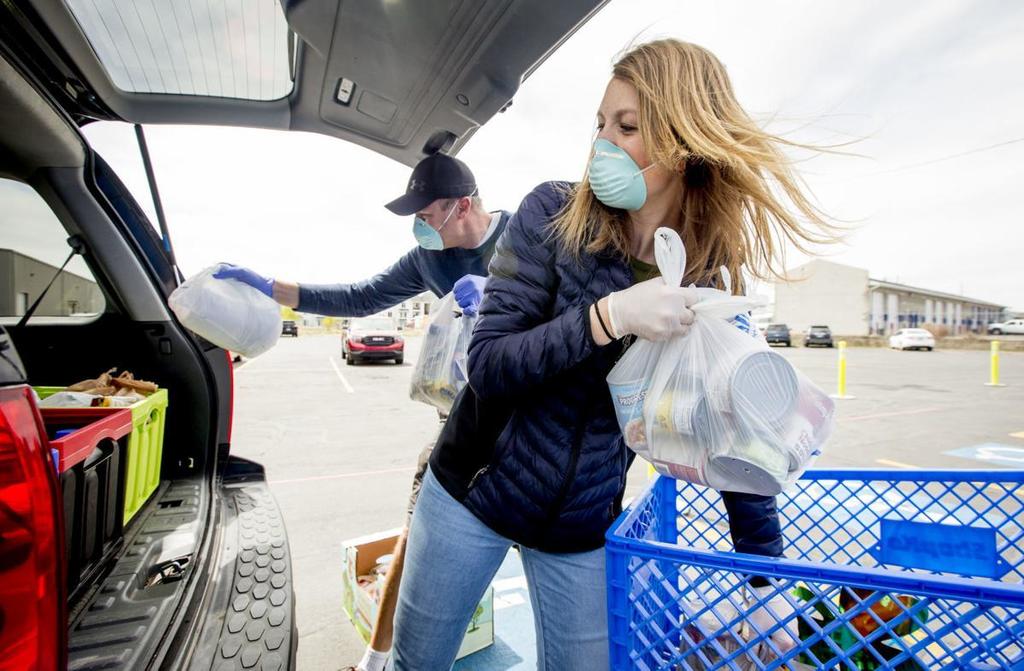 Drive-thru food pantry volunteers load car